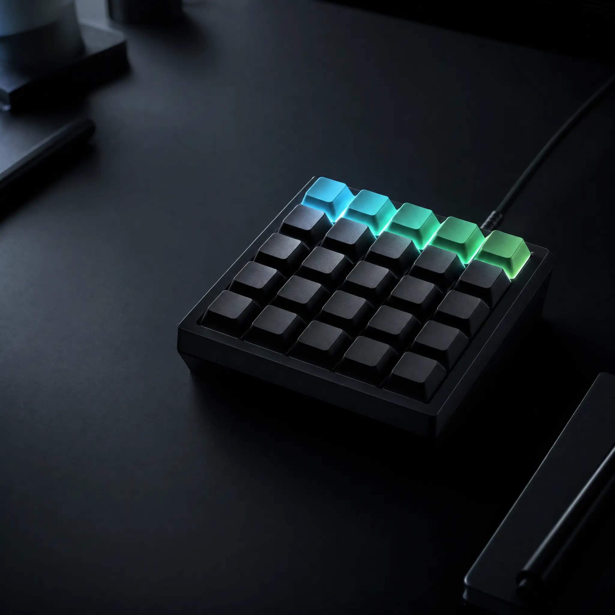Custom macro pad on a matte-black desk, its top row of keycaps glowing in a cyan-to-green gradient mirroring live AI agent status